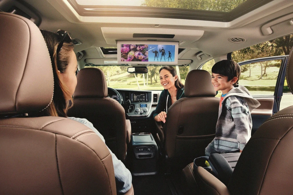Interior of Toyota Sienna 2025 showing spacious cabin, leather seats, triple-zone climate control, and infotainment screens