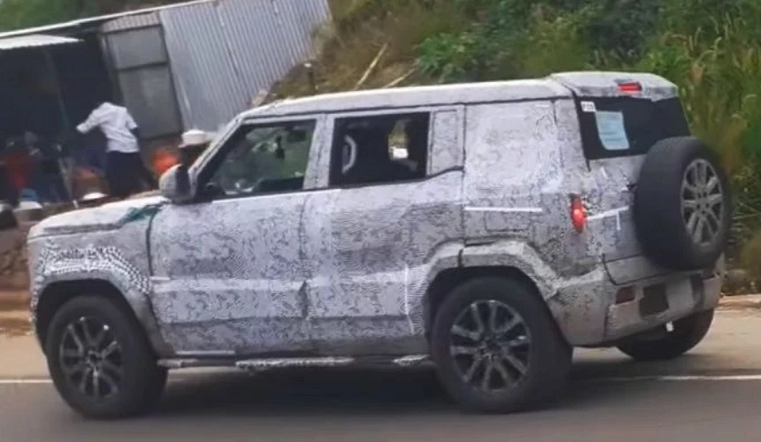 Rear profile of 2025 Mahindra Bolero test mule, highlighting spare wheel-mounted tailgate and refreshed wraparound taillights